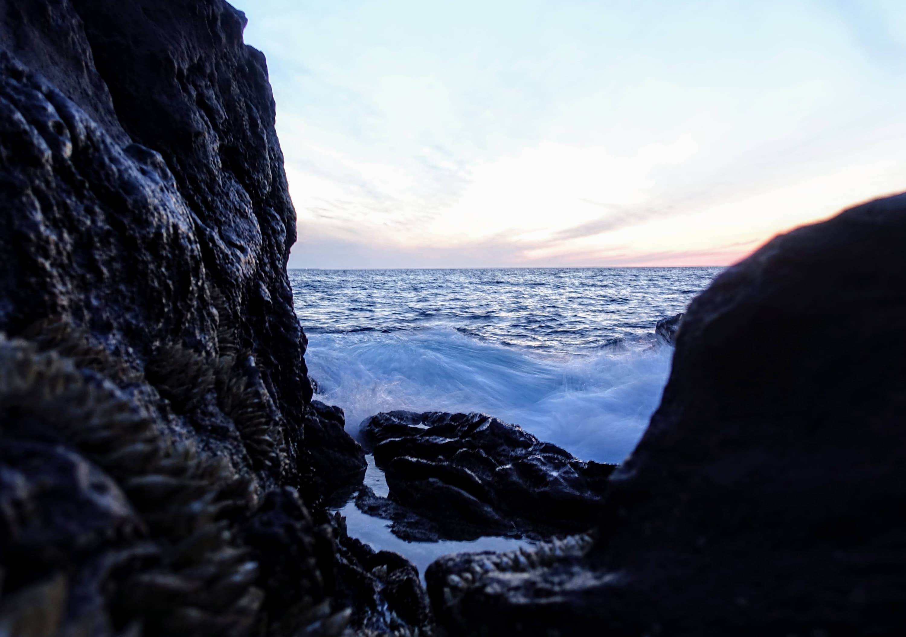 Waves crashing on the shoreline right next to the cliffs!